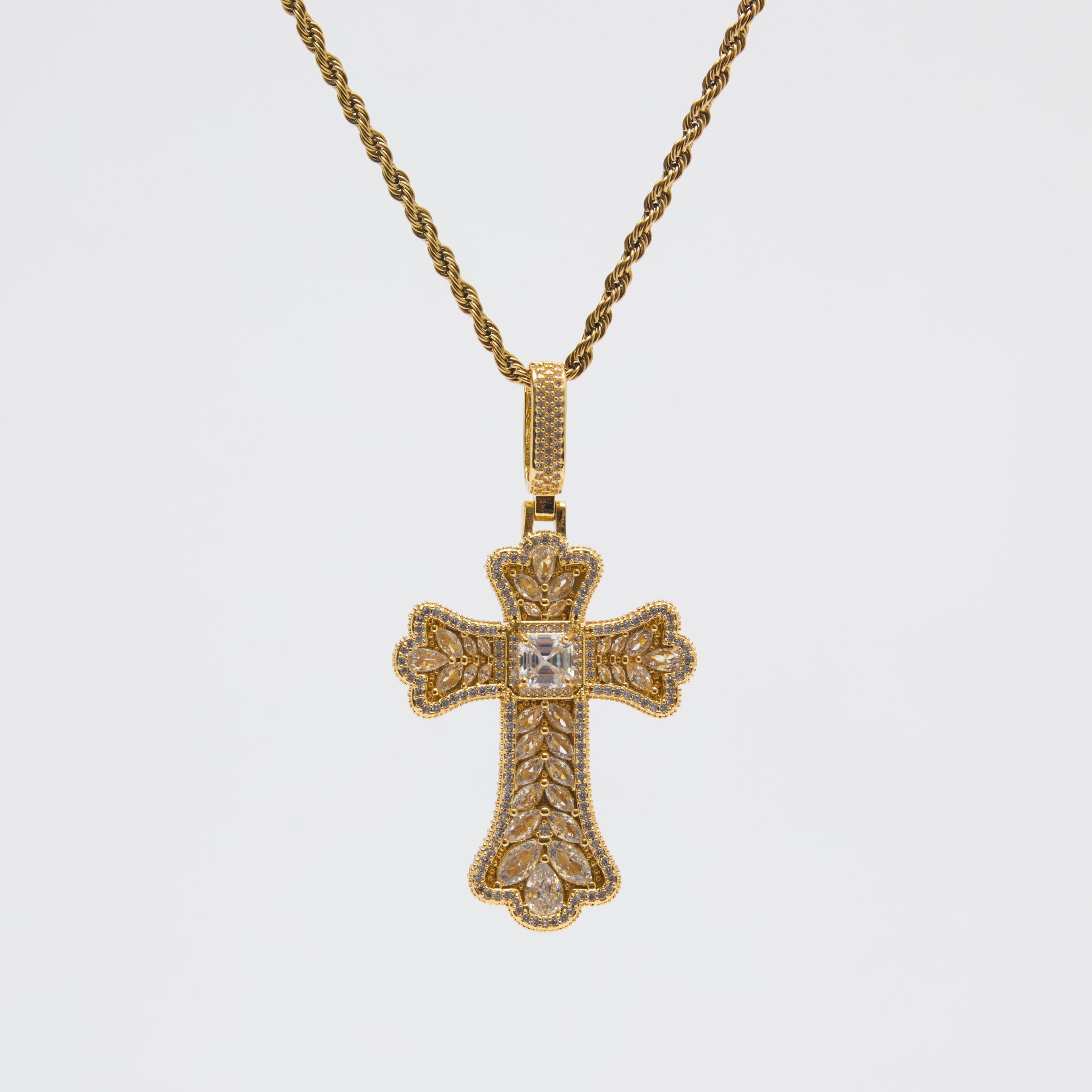 Gold cross pendant necklace on a white background