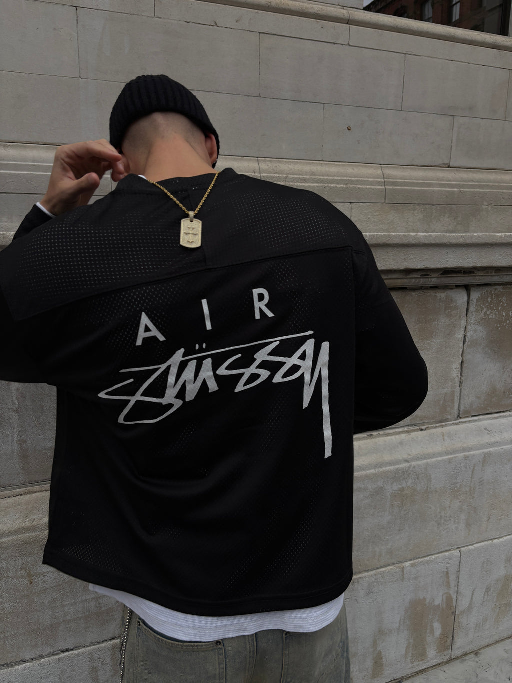 Black jacket with white text on a tiled floor