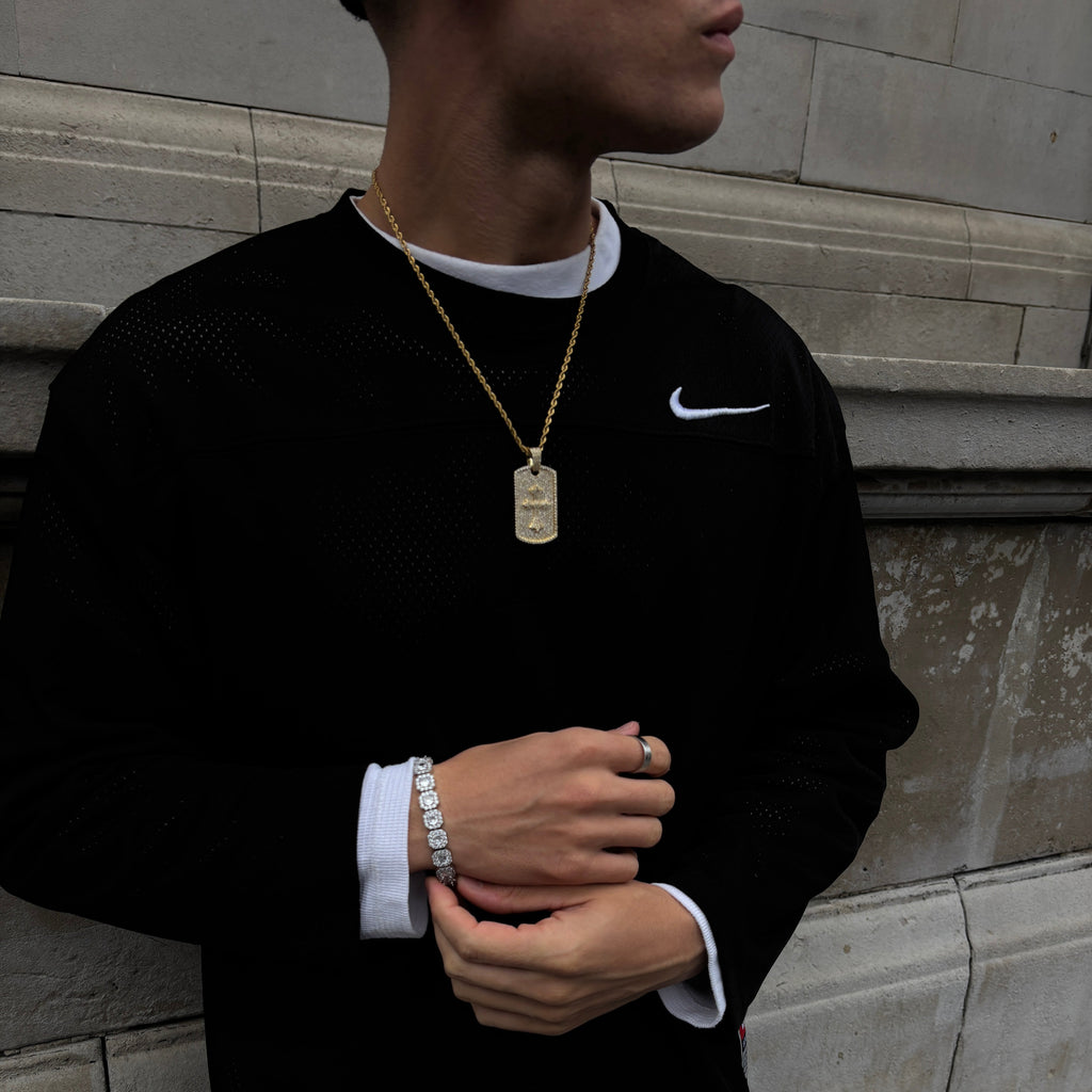 Person wearing a black suit with white trim, standing on a tiled floor.