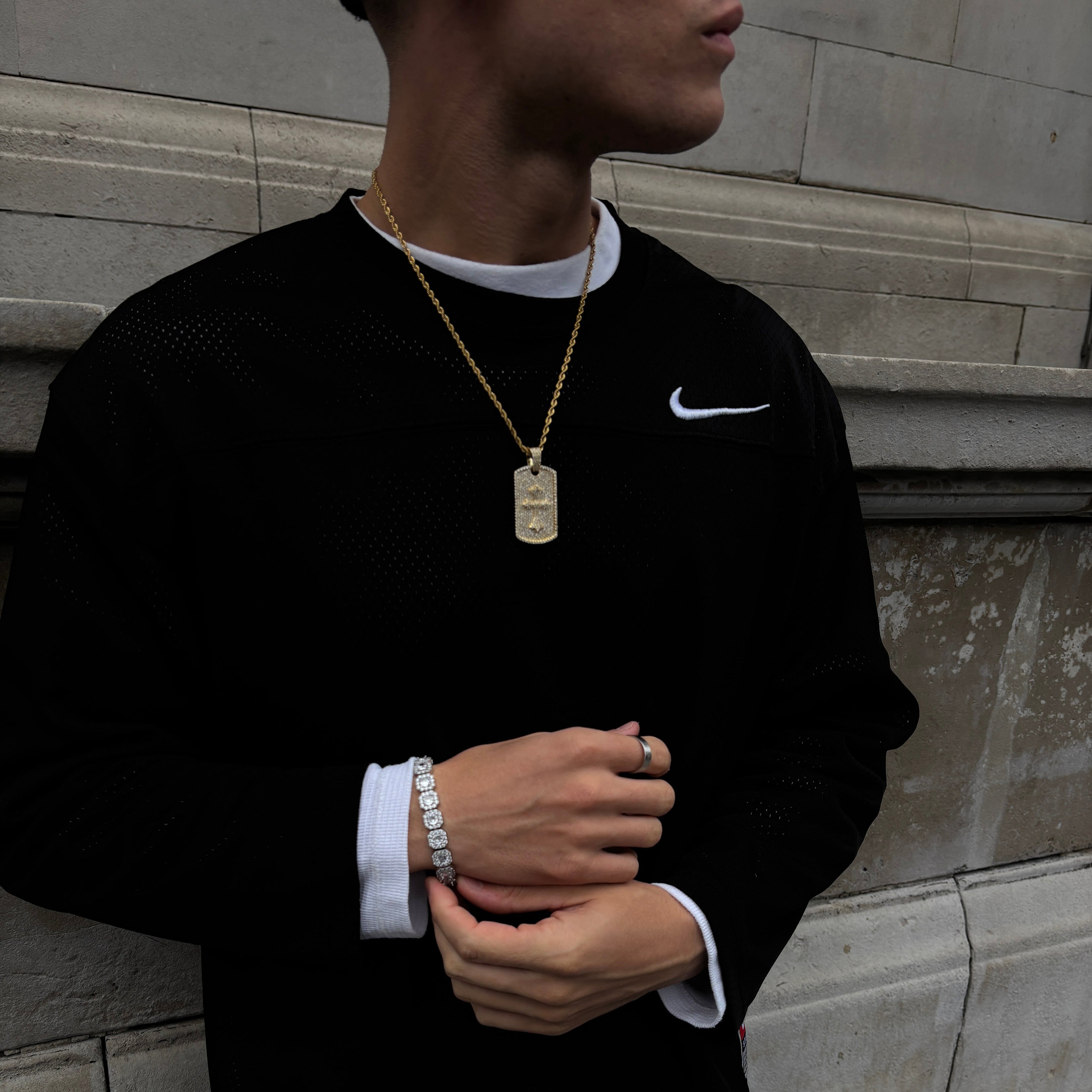 Person wearing a black suit with white trim, standing on a tiled floor.