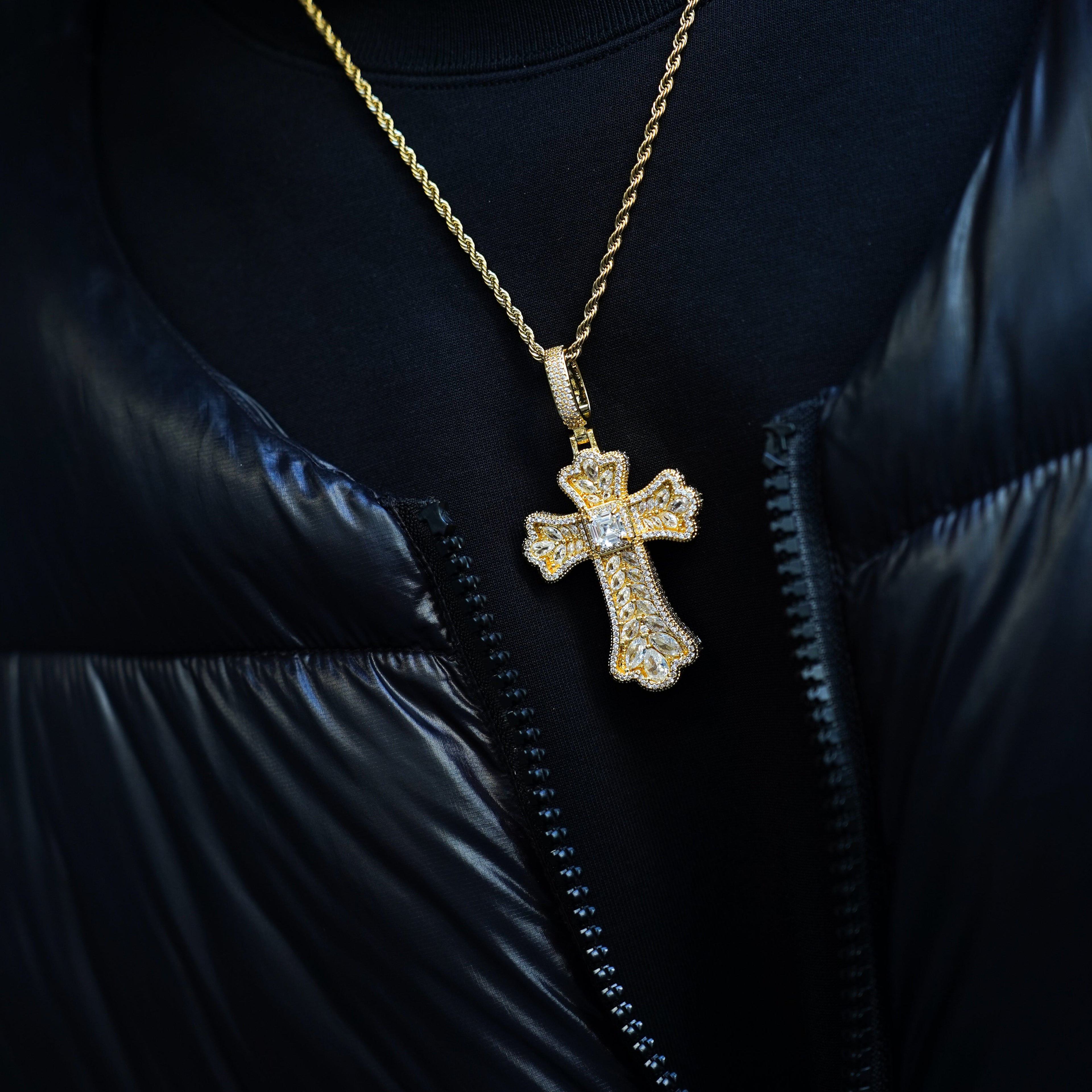 Gold cross necklace with diamonds on a black jacket