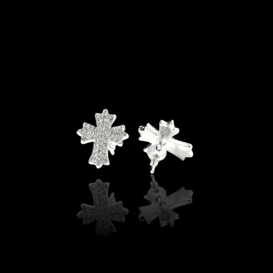 Silver cross-shaped earrings on a black background