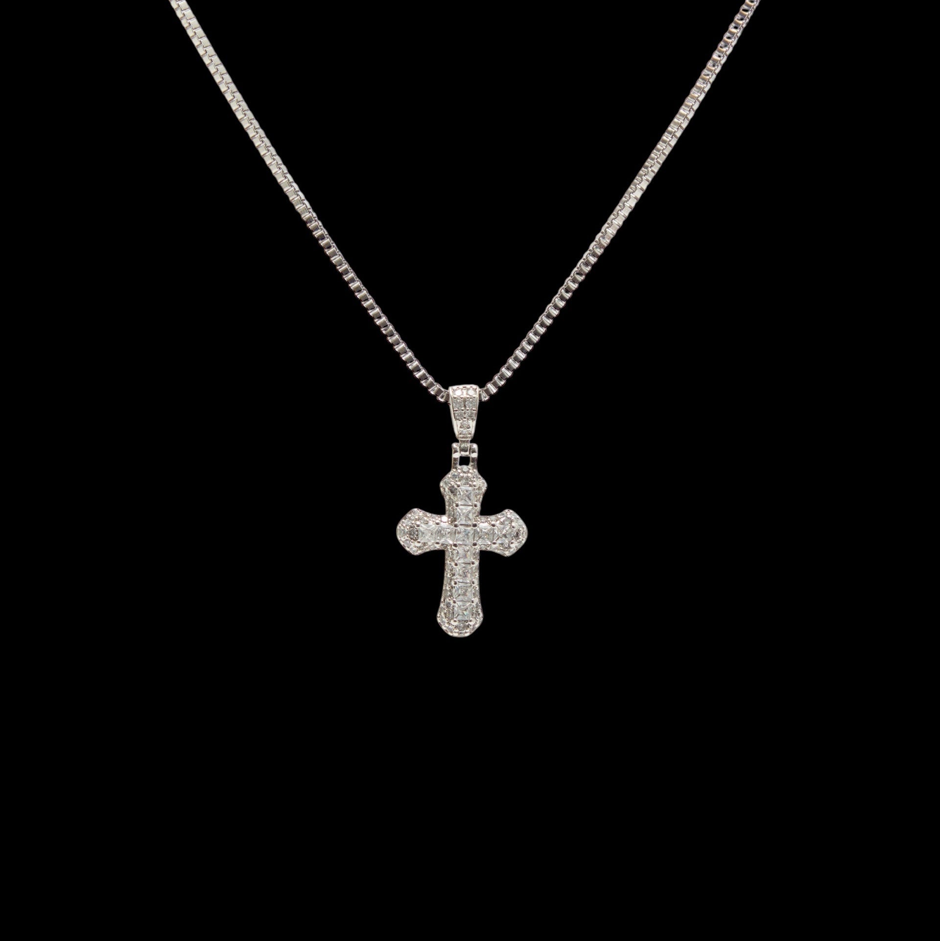 Silver cross pendant necklace on a black background