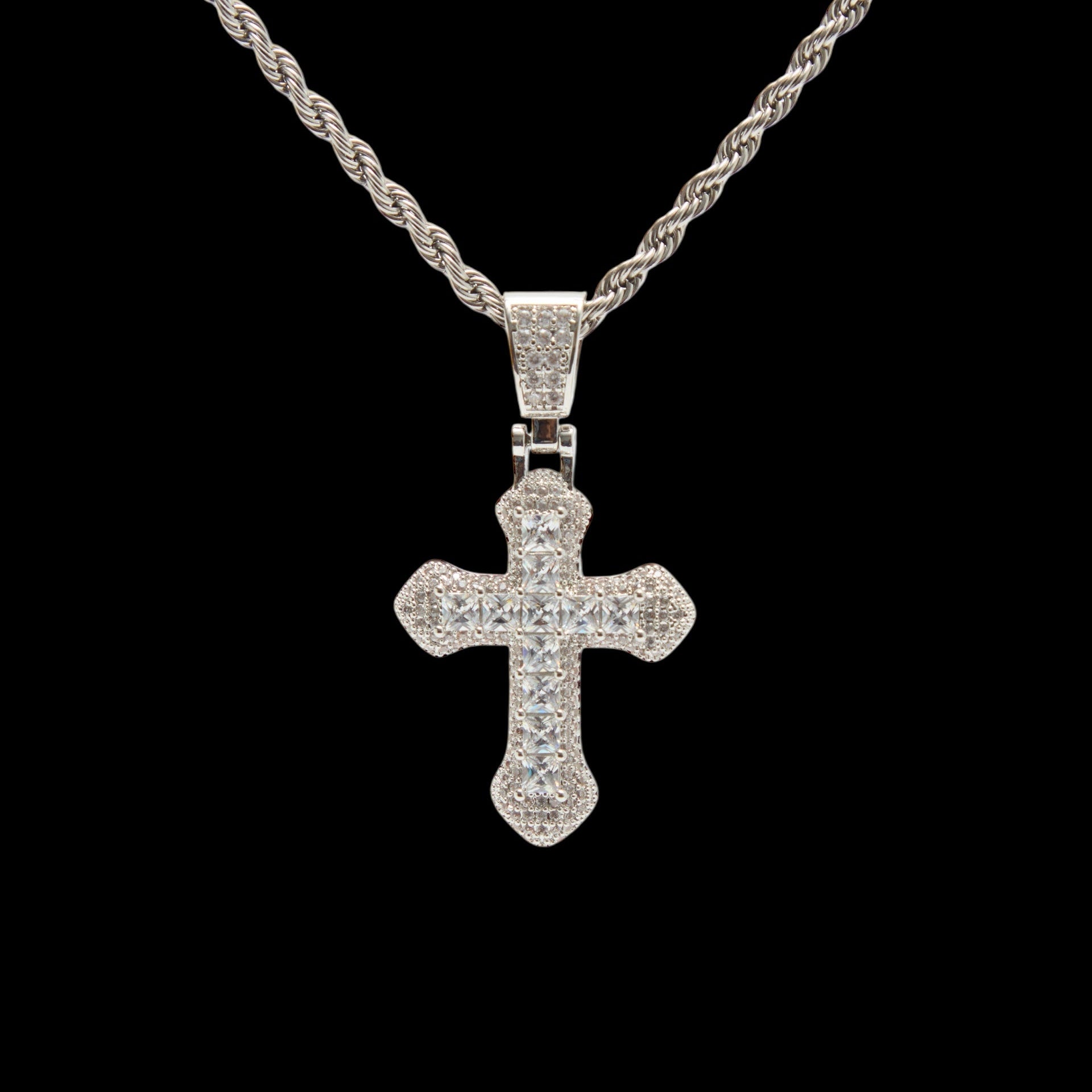 Silver cross pendant necklace on a black background