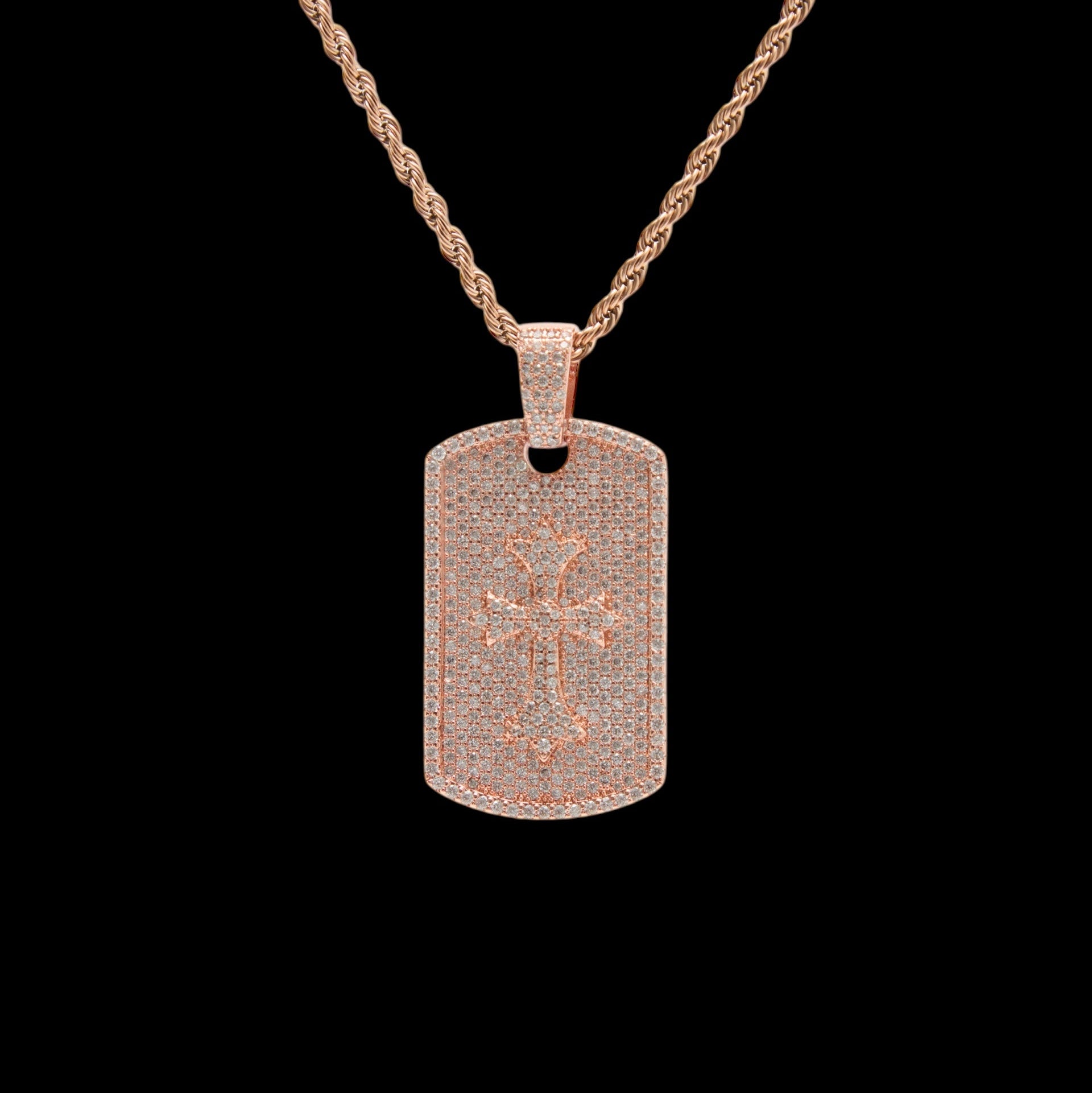 Rose gold dog tag necklace with a star and cross design on a black background