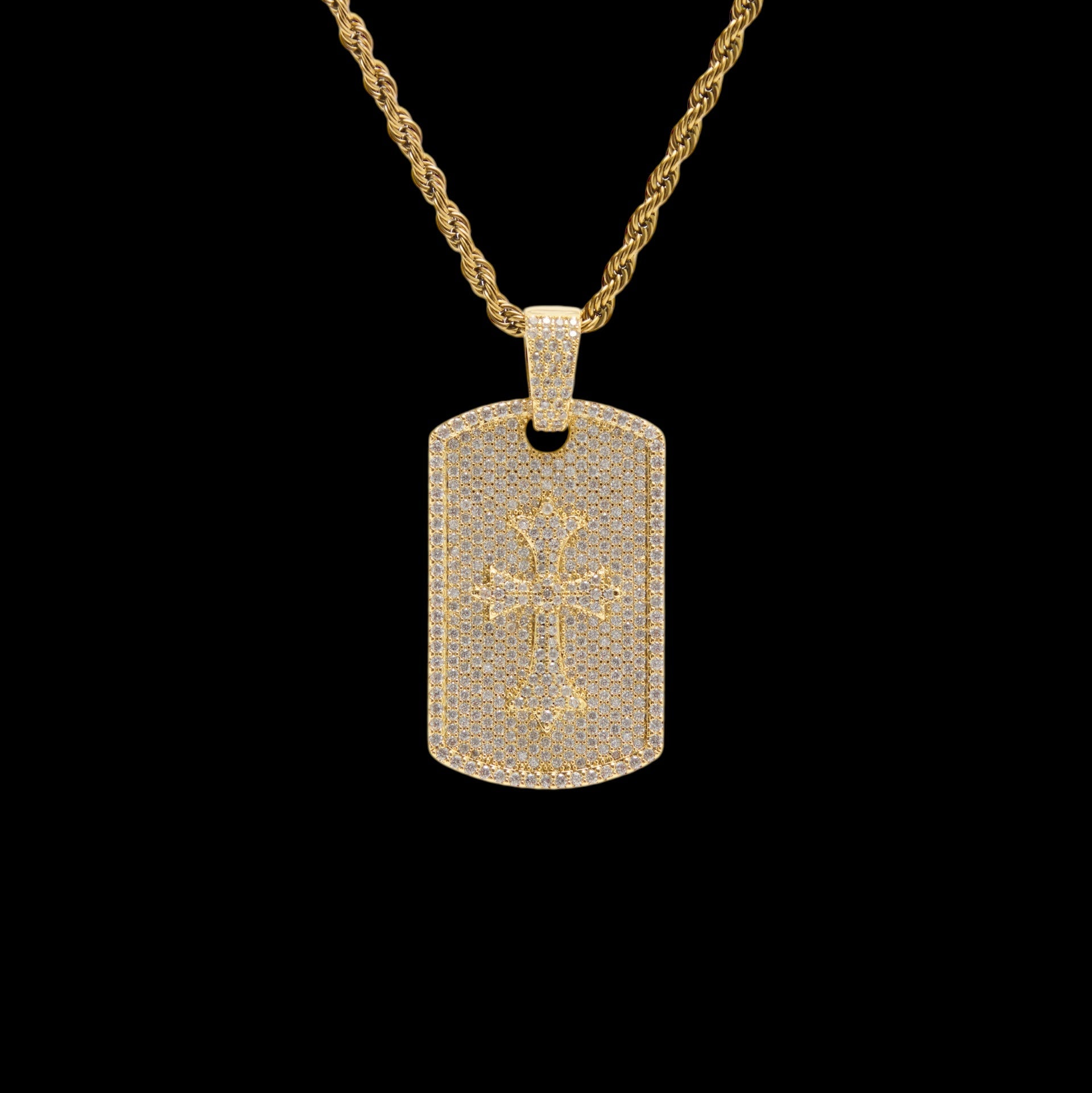 Gold necklace with a dog tag pendant featuring a cross design on a black background