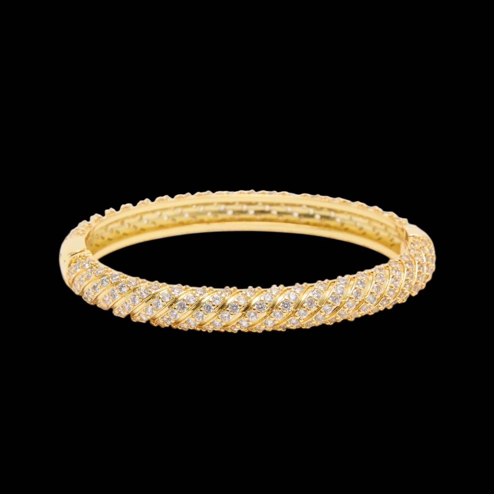 Gold bracelet with diamond accents on a black background