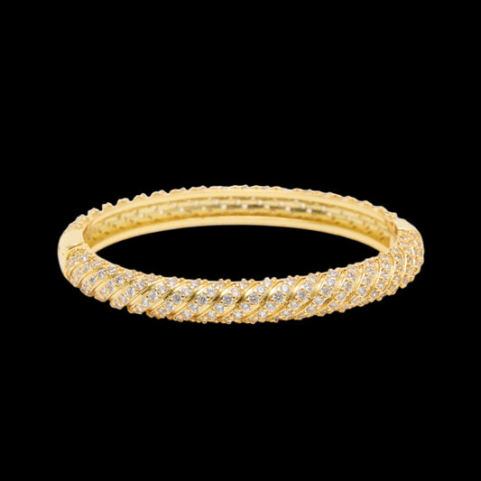 Gold bracelet with diamond accents on a black background