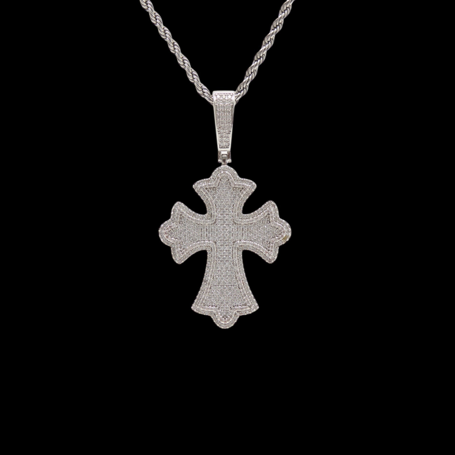 Silver cross pendant on a black background